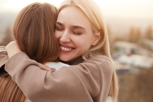 Melhores amigas felizes se abraçando na natureza