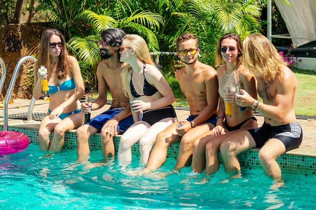 Melhores amigos bebendo limonada enquanto se refrescam na piscina