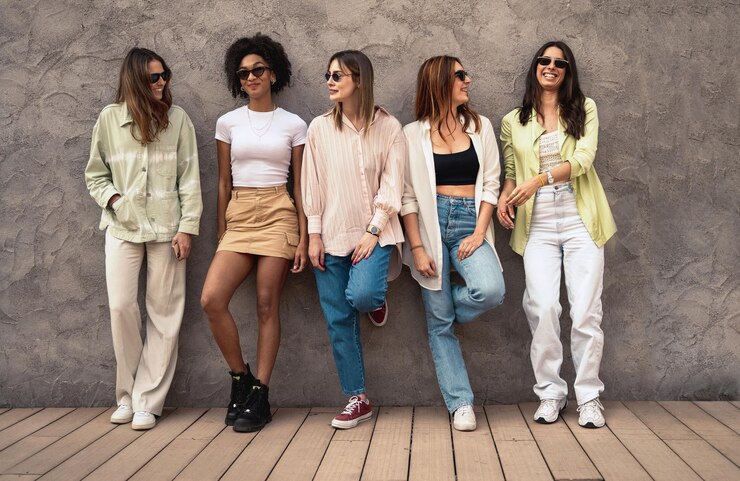 Foto melhores amigos inter-raciais alegres em pé contra a parede, conversando e passando algum tempo juntos. mulheres só conceito de amizade e união.