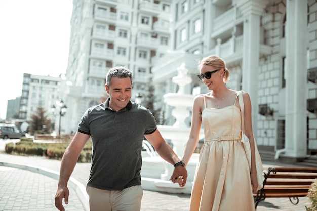 Melhores amigos. Marido e esposa alegres conversando e de mãos dadas durante seu passeio em um dia ensolarado de verão.