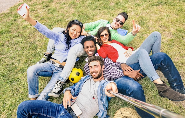 Melhores amigos multirraciais tomando selfie no piquenique do prado