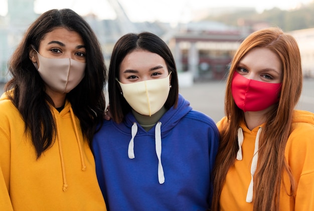 Foto melhores amigos usando máscaras médicas ao ar livre