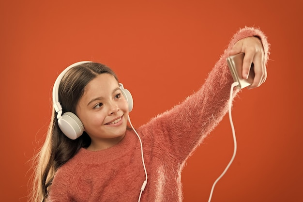 Melhores aplicativos de música grátis Desfrute do conceito de música Desfrute de um som perfeito Criança escuta música fones de ouvido modernos e smartphone Ouça grátis Obter assinatura de conta de música Acesso a milhões de músicas