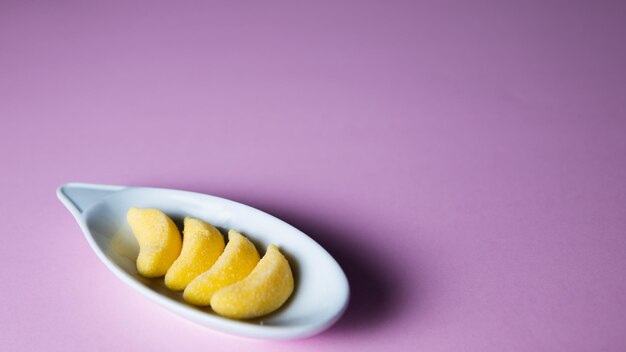 Melocotones en un plato blanco sobre un fondo rosa