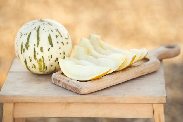 Melón Honeydew dálmata cortado en rodajas y servido en una bandeja de madera