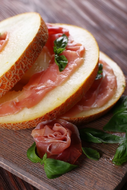 Melón con prosciutto de jamón de Parma en primer plano de la mesa de madera