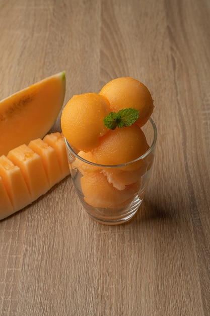 Foto melón de pulpa amarilla se recogió en una bola redonda como helado se puso en un vaso transparente