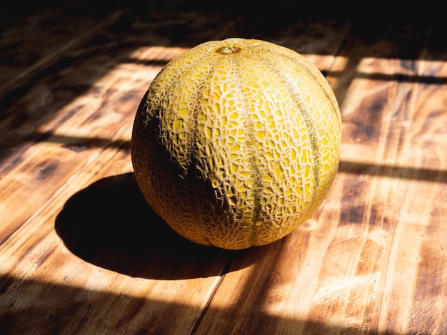 Melón redondo aislado en una mesa de madera