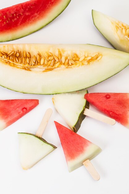 Melón a y sandía en forma de paletas de hielo sobre un fondo blanco