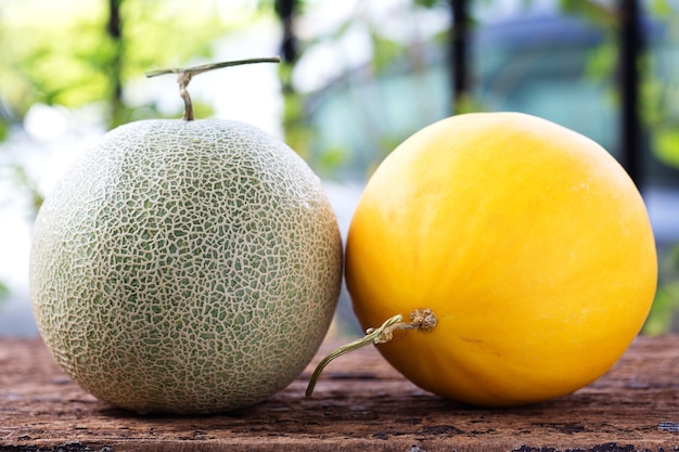 Melón verde y melón amarillo en la mesa de madera.