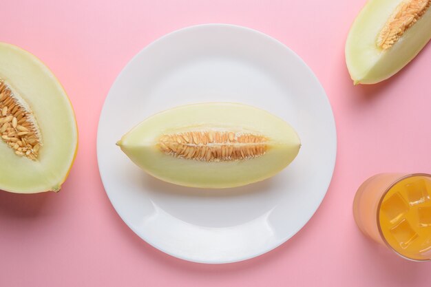 Melone auf pastellrosa Oberfläche geschnitten.