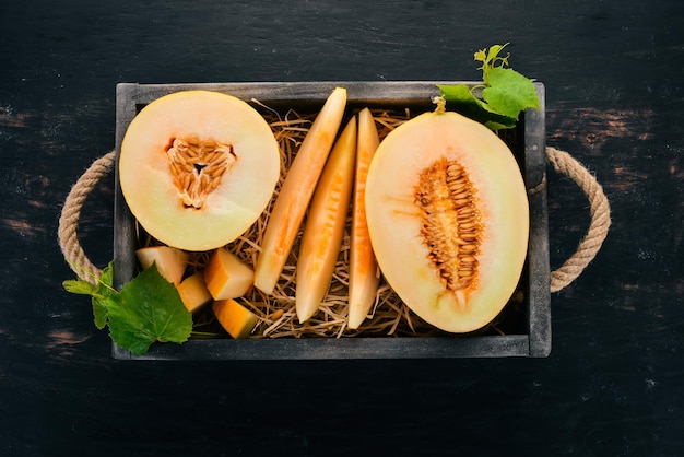 Melone in einer Holzkiste In Stücke geschnittene Melone Auf einem hölzernen Hintergrund Freier Platz für Text Ansicht von oben