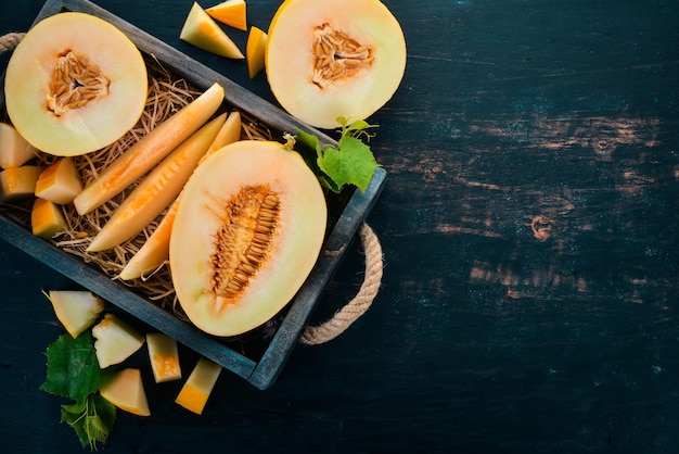 Melone in einer Holzkiste In Stücke geschnittene Melone Auf einem hölzernen Hintergrund Freier Platz für Text Ansicht von oben