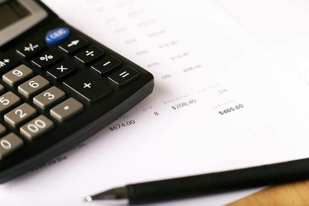 Membrete de factura con calculadora y bolígrafo, papel financiero y herramientas de oficina