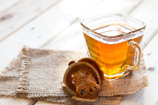 Foto membrillo secado y agua de membrillo en vidrio en la tabla de madera, bebidas sanas, hierba tailandesa.