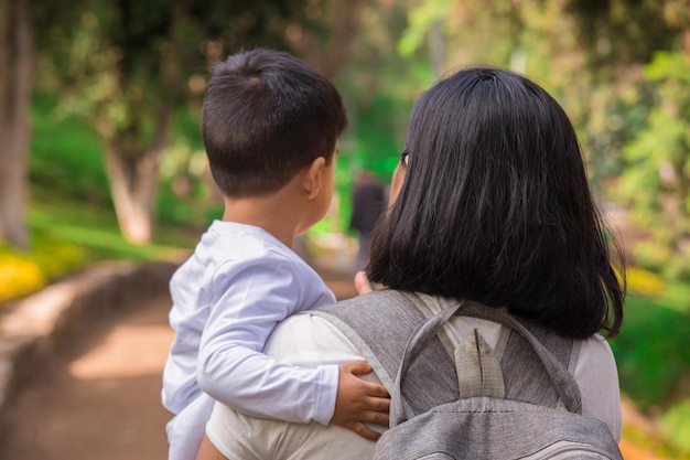 Membros da família de mãos dadas e caminhando para trás em um parque juntos família