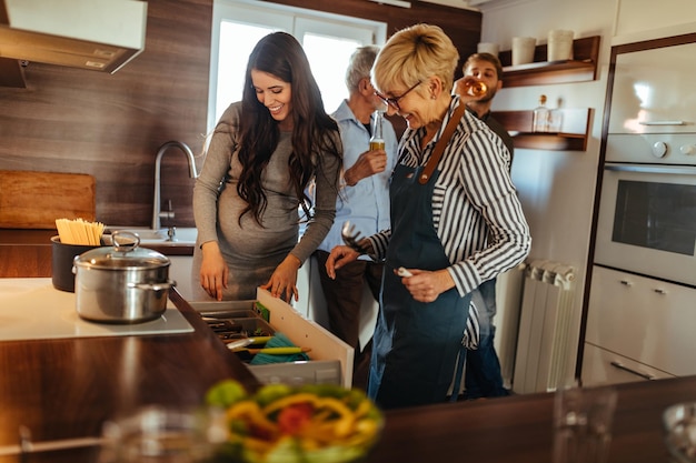 Membros da família feminina cozinhando enquanto os homens estão socializando juntos em casa