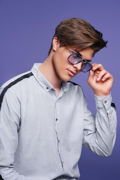 Men39s Accessoires-Optik Gut aussehender Kerl, der im Hemd und in der modernen Sonnenbrille sitzt Studioporträt