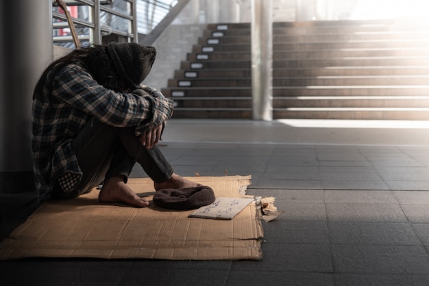 Mendigos, personas sin hogar sentados en el piso Acérquese a la prohibición, pida una fracción del dinero