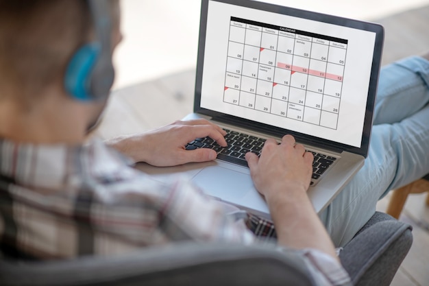 Menegement de tempo. um jovem empresário verificando seu calendário de trabalho online