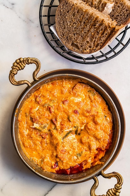 Menemen turco tradicional com ovos, salsicha, sucuk e tomate, fundo branco, vista superior