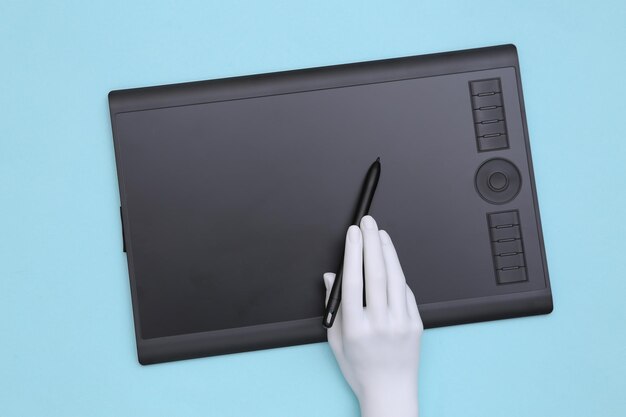 Foto menequins hand arbeitet auf einem grafiktablett. blauer hintergrund