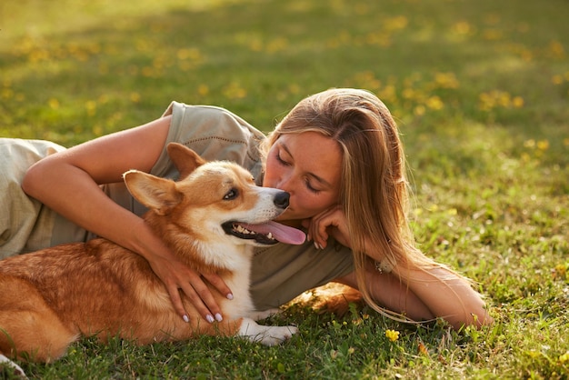 menina abraçando pembroke welsh corgi no parque em tempo ensolarado conceito de cães felizes