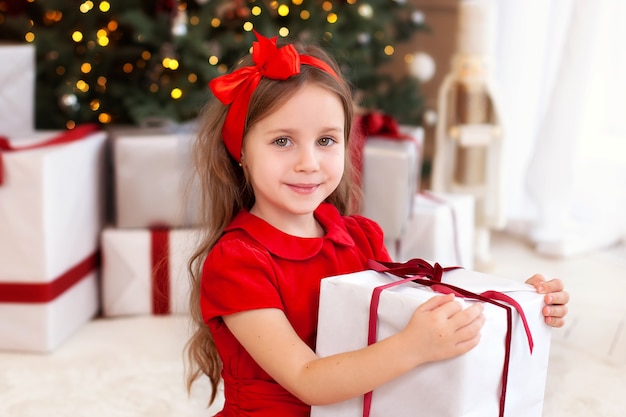 Menina abre presente na sala de estar no Natal