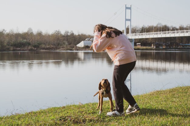 Menina acariciando cachorro abandonado no lago. adotando animais. poti, geórgia.