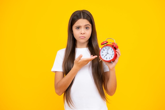 Menina adolescente 12 13 14 anos olha para o despertador Hora de fazer compras Bom dia verificando o tempo