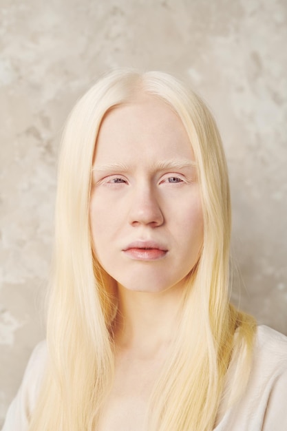 Menina adolescente albina com cabelo longo e liso posando na frente da câmera