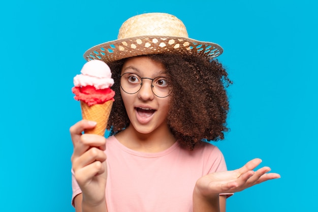 Menina adolescente bonita afro com chapéu e tomando um sorvete. conceito de verão