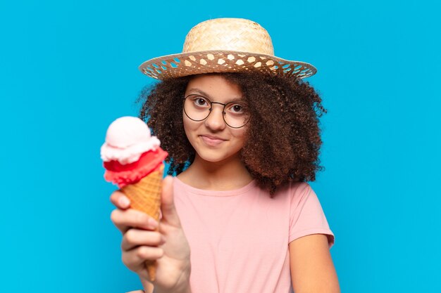 Menina adolescente bonita afro com chapéu e tomando um sorvete. conceito de verão