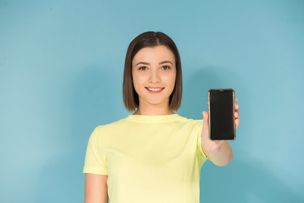 Menina adolescente caucasiana segurando um celular