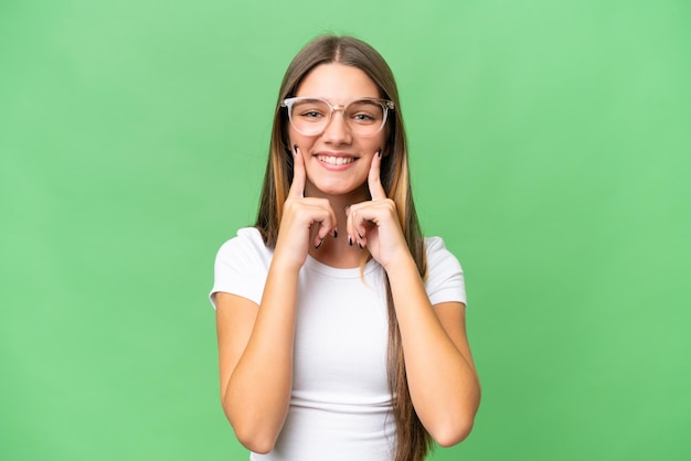 Menina adolescente caucasiana sobre fundo isolado, sorrindo com uma expressão feliz e agradável