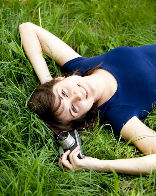 Menina adolescente com a câmera no parque verde.