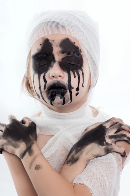 Menina adolescente com ataduras de múmia no halloween em branco isolado