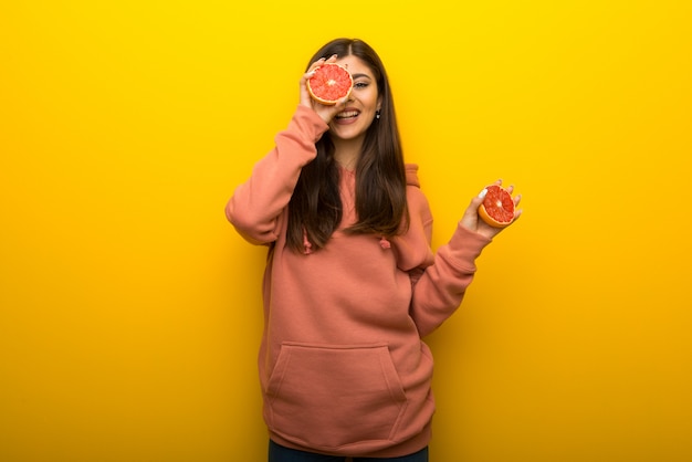 Menina adolescente, com, cor-de-rosa, sweatshirt, ligado, experiência amarela, com, laranjas