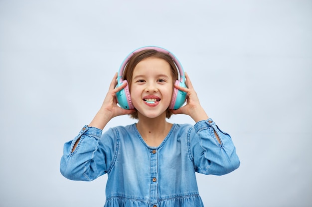 Menina adolescente com goma de mascar ouvindo música em fones de ouvido