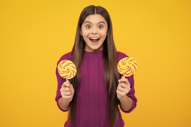 Foto menina adolescente com pirulito doce criança feliz anos comendo pirulito grande açúcar doces doces