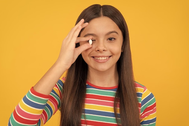 Menina adolescente com produtos de pílula natural apresentando criança feliz de produto vitamínico com pílula