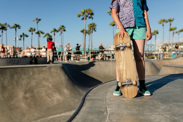 Menina adolescente com um skate em um skatepark em Venice Beach, LA