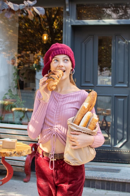 Foto menina adolescente comendo um croissant fresco