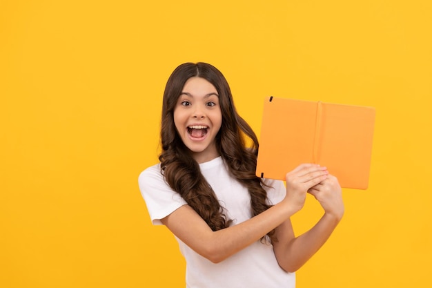 Menina adolescente da escola espantada pronta para estudar com educação de caderno