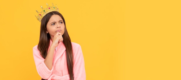 Menina adolescente egoísta e pensativa em casa roupão de banho e ego de coroa de princesa Criança rainha princesa no design de cartaz horizontal de coroa Espaço de cópia de cabeçalho de banner