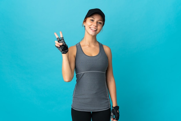 Foto menina adolescente em esporte sorrindo e mostrando sinal de vitória