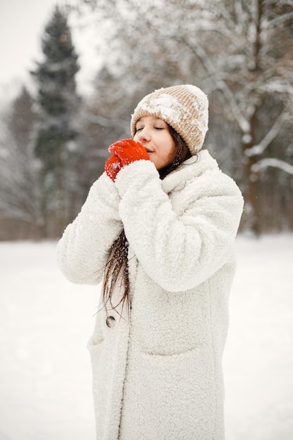 Menina adolescente em luvas vermelhas em winter park e posando para uma foto