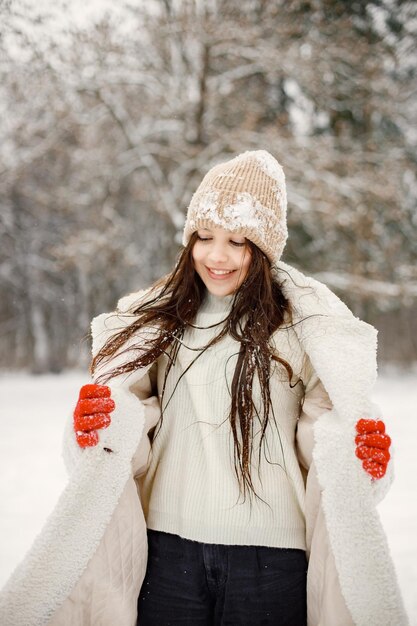 Menina adolescente em luvas vermelhas em winter park e posando para uma foto