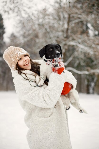 Menina adolescente em winter park e segurando um cachorro preto