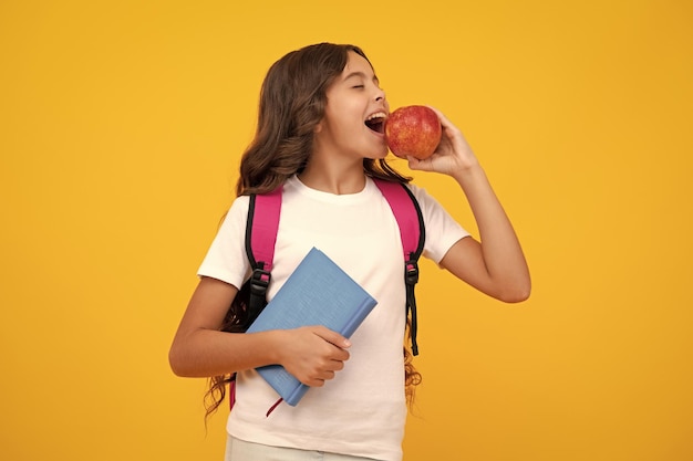 Foto menina adolescente espantada aluna de uniforme escolar segura maçã conceito de escola e educação de volta à escola estudante adolescente estudando expressão animada alegre e feliz